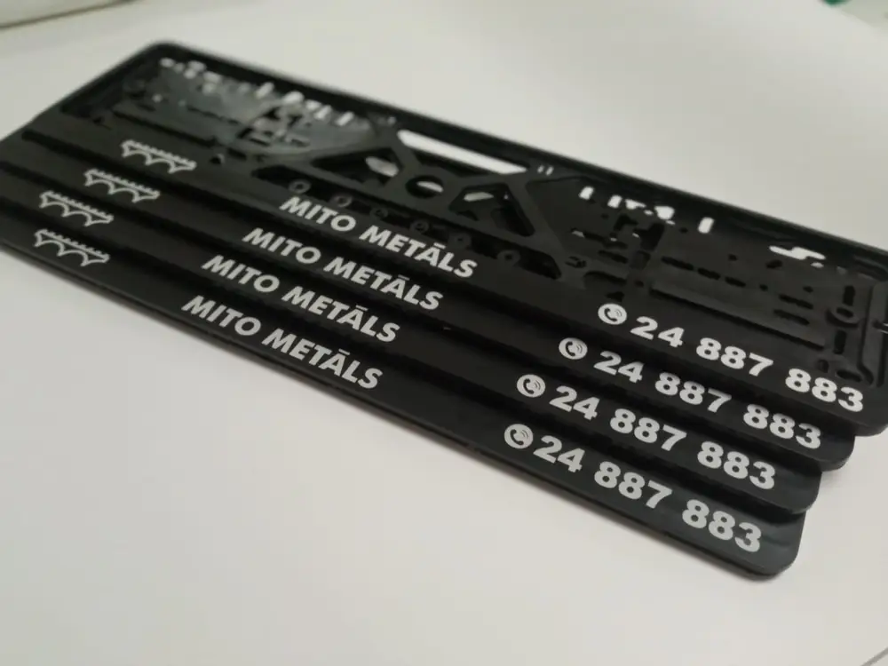 Black number plate frames with white Mito Metāls lettering and a phone number