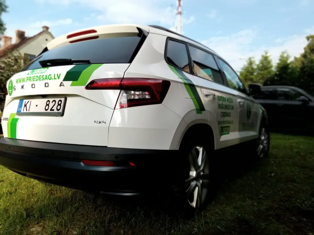 White Škoda SUV with green stripes and the text priedesag.lv