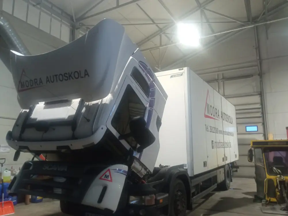 Scania truck in the workshop with Modra autoskola lettering on the cab and box