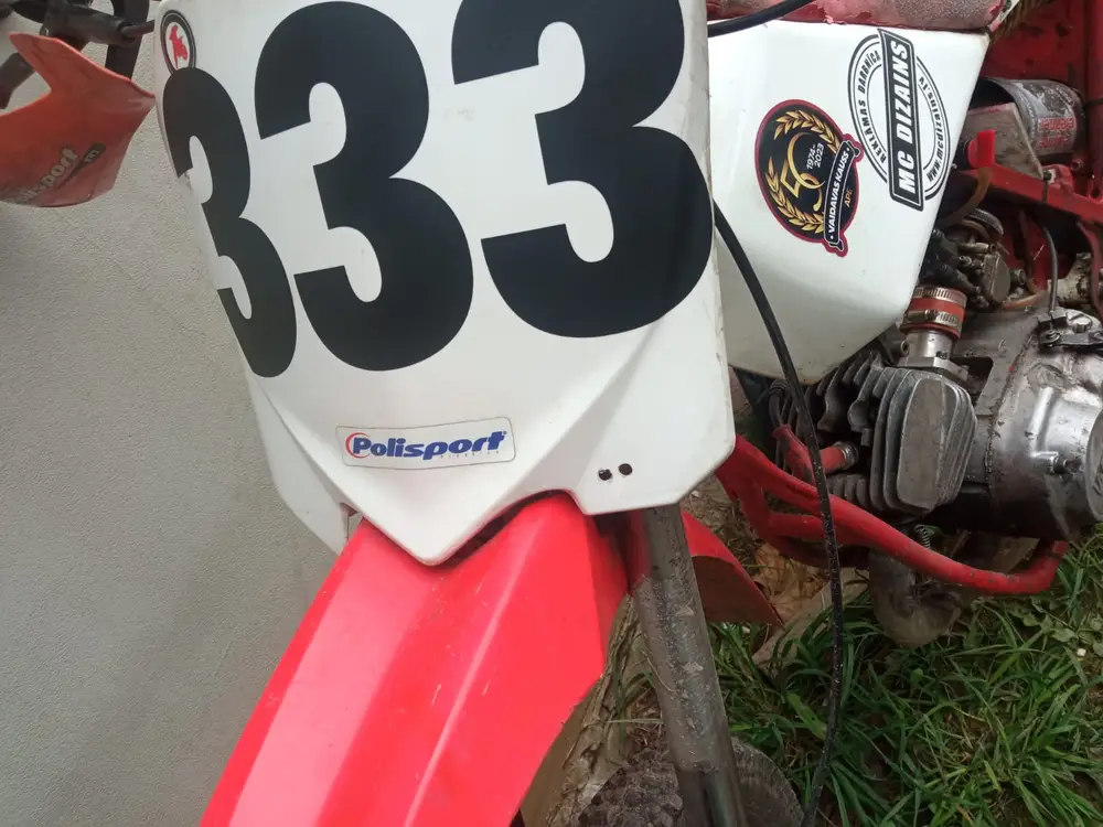 Front plate of a motocross bike with the black number 333 and stickers