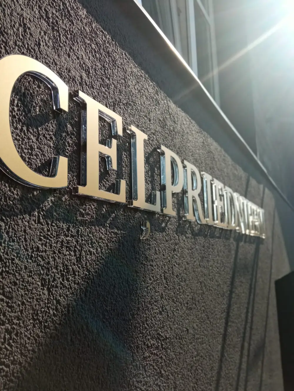 Mirror-finish 3D letters on a dark rendered facade