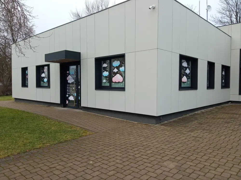 Single-storey building with cloud and bird graphics on the windows and doors