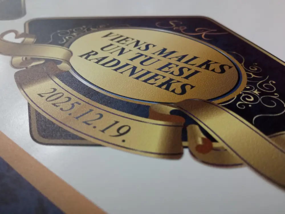 Label with a gold ribbon and the text "Viens malks un tu esi radinieks"