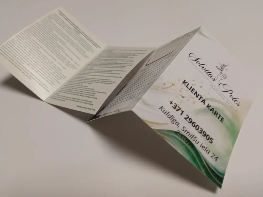 Folded client card reading Solvitas Poles skaistuma studija, with contact details