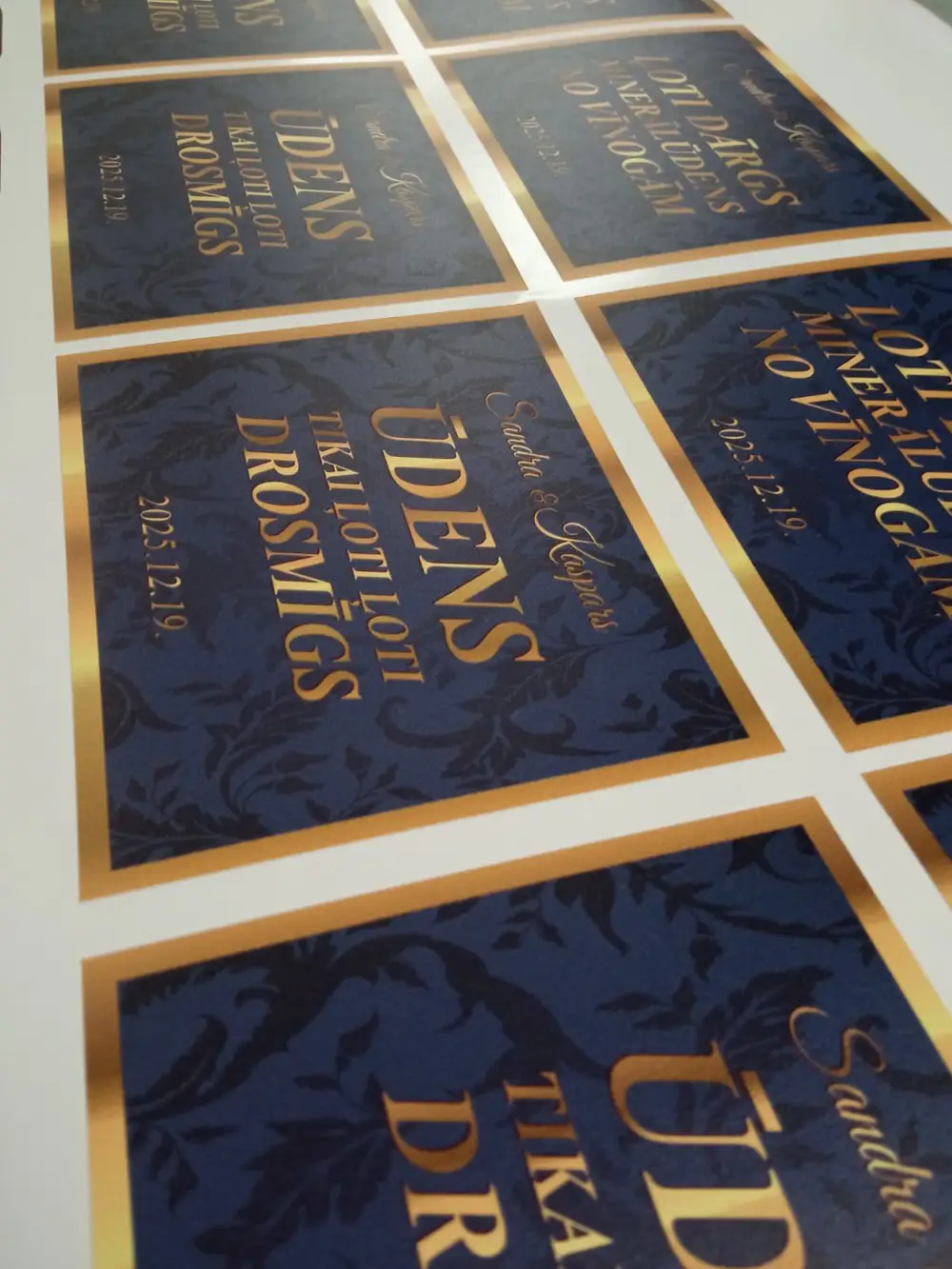 Sheet of labels with the gold text "Ūdens, tikai ļoti ļoti drosmīgs"