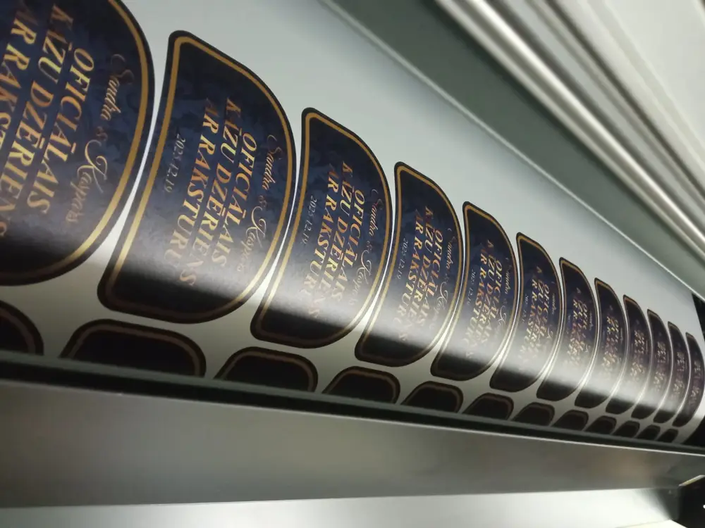 A roll of wedding drink labels coming out of a wide-format printer