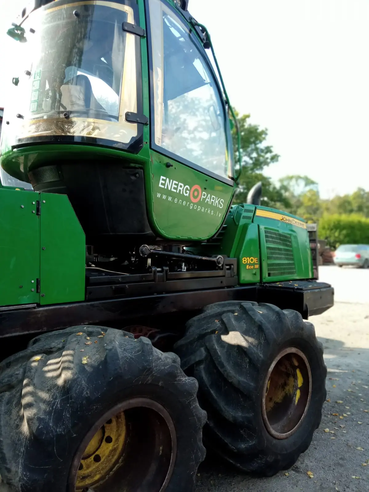 Green John Deere forestry machine cab with a white Energoparks logo and address on the door