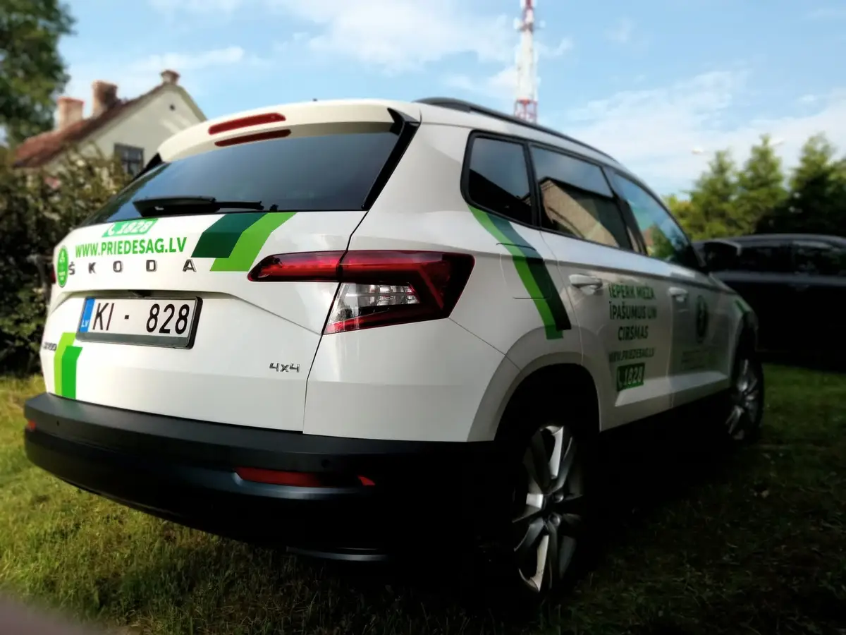 White Škoda SUV with green stripes, www.priedesag.lv on the back and text on the side doors